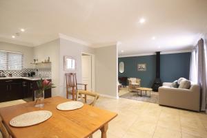 a kitchen and living room with a table and a dining room at Stony Brook Cottages in Franschhoek