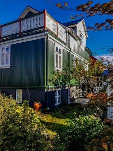 una casa pintada de verde y blanco en Old Charm Apartment - Keflavík Downtown, en Keflavík