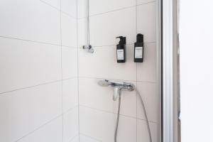 a bathroom with a shower with two bottles on the wall at FULL HOUSE Studios - The Forest Apartment - Nespresso inkl in Halle an der Saale