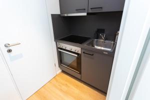 a small kitchen with a sink and a stove at FULL HOUSE Studios - The Forest Apartment - Nespresso inkl in Halle an der Saale