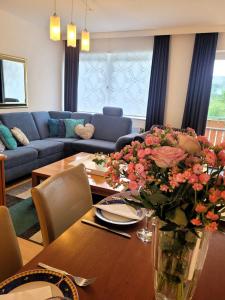 ein Wohnzimmer mit einem Tisch und einer Blumenvase in der Unterkunft Winterberg Appartement 21028 in Winterberg