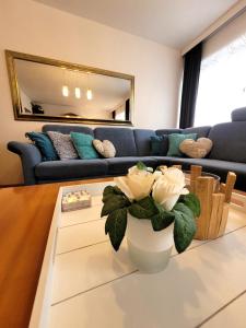 a living room with a couch and a vase with flowers at Winterberg Appartement 21028 in Winterberg
