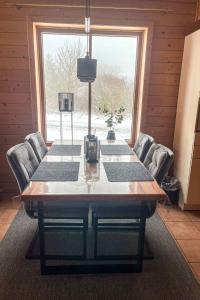une table à manger avec des chaises et une grande fenêtre dans l'établissement Holiday Home Auerhahn-2 by Interhome, à Hasselfelde