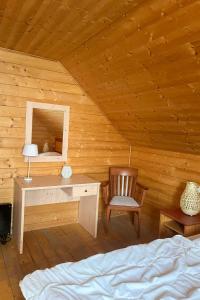 - une chambre avec un bureau et une chaise dans une cabane en rondins dans l'établissement Holiday Home Auerhahn-2 by Interhome, à Hasselfelde