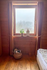 - une chambre dotée d'une fenêtre avec une plante dans un panier dans l'établissement Holiday Home Auerhahn-2 by Interhome, à Hasselfelde