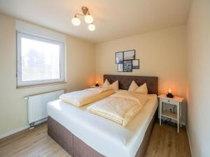 a bedroom with a large white bed with two lamps at Apartment Müritz Ferienpark Röbel-20 by Interhome in Röbel +10 photos