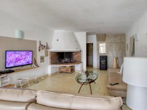 ein Wohnzimmer mit einem Sofa und einem TV in der Unterkunft Apartment La Bastide Neuve - SCS125 by Interhome in Saint-Cyr-sur-Mer