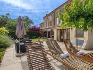 eine Terrasse mit Liegestühlen und einem Sonnenschirm in der Unterkunft Apartment La Bastide Neuve - SCS125 by Interhome in Saint-Cyr-sur-Mer