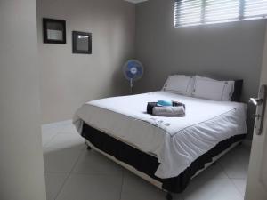 a bedroom with a large bed in a white room at Korsmans Retreat - Large Modern Self-Catering Flat in Benoni