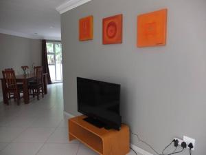 a living room with a flat screen tv on a wall at Korsmans Retreat - Large Modern Self-Catering Flat in Benoni