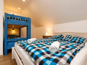 a blue and white bed in a room with a bunk bed at Apartment Hora Jizera by Interhome in Desná