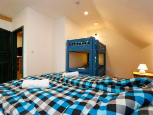 a blue and white checkered bed in a room at Apartment Hora Jizera by Interhome in Desná