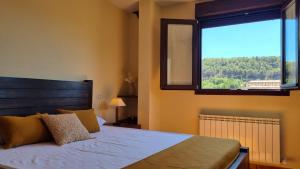 um quarto com uma cama e uma grande janela em Casa Rural La Posada de Santa Teresa em Pastrana
