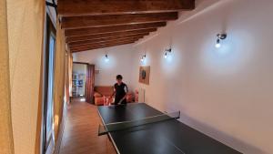 a woman in a room with a ping pong table at Casa Rural La Posada de Santa Teresa in Pastrana
