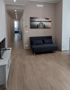 a living room with a couch and a television at FIUMARA MALL Apartment in Genoa