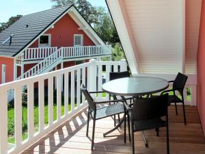 a balcony with a table and chairs and a house at Apartment Müritz Ferienpark Röbel-21 by Interhome in Röbel