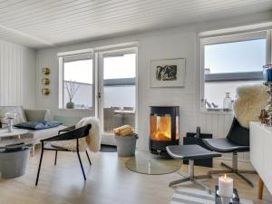 a living room with a fireplace and a couch at Apartment Tarvo - 500m from the sea in NW Jutland by Interhome in Pandrup