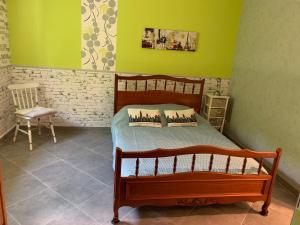 sypialnia z drewnianym łóżkiem i krzesłem w obiekcie maison avec jardin et parking privé w mieście Meschers-sur-Gironde