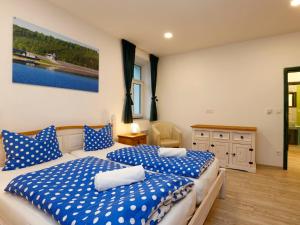 two beds in a bedroom with blue and white sheets at Apartment Přehrada Souš by Interhome in Desná