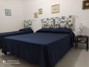 1 dormitorio con 2 camas y sábanas azules en Casa Vacanze Villa Verde - Ribera, en Ribera