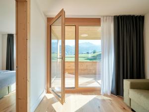 1 dormitorio con una gran puerta de cristal que da a un balcón en Apartment Catrina Experience-1 by Interhome, en Disentis