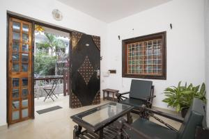 a living room with a door and a glass table at Homes Stay In Candolim GOA in Marmagao