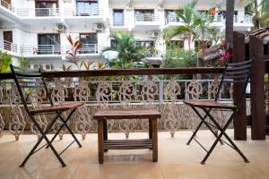 Homes Stay In Candolim GOA في Marmagao: كرسيين وطاولة على شرفة