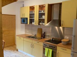 eine Küche mit gelben Schränken und einem Waschbecken in der Unterkunft Apartment Hasenstall - Top 8 by Interhome in Grünau im Almtal