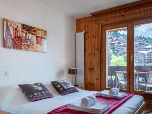 una camera da letto con un letto, asciugamani e una finestra di Apartment Lake Placid B5 by Interhome a Nendaz