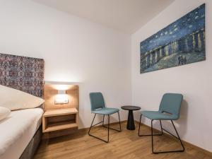 2 sillas y una mesa en una habitación con cama en Apartment Montec-3 by Interhome, en Hippach