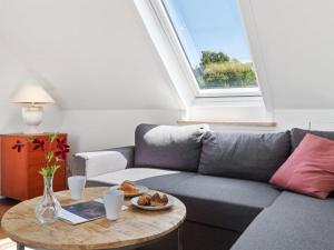 a living room with a grey couch and a table at Apartment Riitta - 250m from the sea in Bornholm by Interhome in Neksø