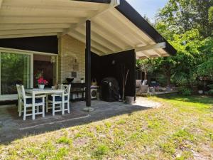 a patio with a table and chairs under awning at Holiday Home Bistra - 280m from the sea in Sealand by Interhome in Vejby