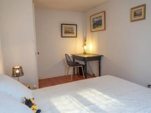 una camera con letto e scrivania con lampada di Apartment Petit nid de Pully by Interhome a Cully