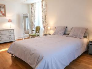 1 dormitorio con 1 cama blanca grande y espejo en Apartment Petit nid de Pully by Interhome en Cully