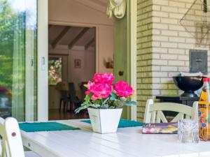 a white vase with pink flowers on a table at Holiday Home Bistra - 280m from the sea in Sealand by Interhome in Vejby