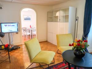 - un salon avec deux chaises, une table et une télévision dans l'établissement Apartment Petit nid de Pully by Interhome, à Cully