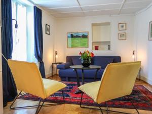 Apartment Petit nid de Pully by Interhome في كولي: غرفة معيشة مع كراسي صفراء وأريكة زرقاء