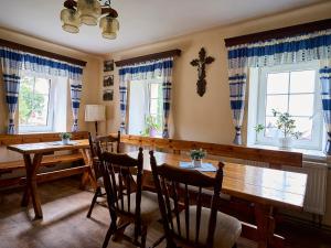 - une salle à manger avec une table, des chaises et des fenêtres dans l'établissement Holiday Home Penzion minigolf Příchovice by Interhome, à Kořenov