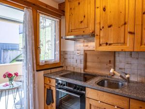 una cocina con armarios de madera y fregadero en Apartment Chesa Muntarütsch by Interhome en Samedan