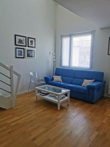 een woonkamer met een blauwe bank en een salontafel bij Duplex lumineux Saint Ouen sur Seine in Saint-Ouen