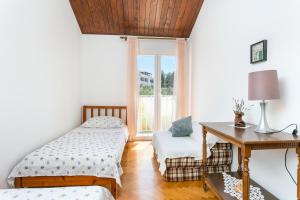 una camera con 2 letti, una scrivania e una finestra di Apartments by the sea Mirca, Brac - 732 a Mirce