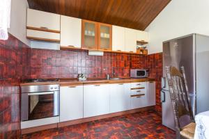 a kitchen with white cabinets and red tiles at Apartments by the sea Mirca, Brac - 732 in Mirce