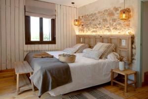 1 dormitorio con 1 cama blanca grande y pared de piedra en Finca San Benito, piscina privada, a estrenar!, en Mejorada