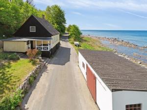 a house on the side of a road next to the ocean at Holiday Home Scarlet - 5m from the sea in Bornholm by Interhome in Hasle