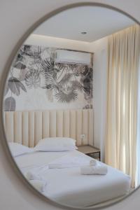 espejo reflejo de una cama en un dormitorio en La Maison Boutique Hotel, en Ksamil