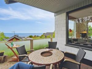 a patio with a table and chairs and a window at Holiday Home Dika - 400m from the sea in Bornholm by Interhome in Hasle