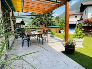 une terrasse avec une table et des chaises sous une pergola en bois dans l'établissement Apartment Rätia II by Interhome, à Pfunds