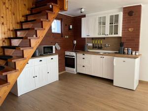 una cocina con armarios blancos y una escalera de caracol en Holiday Home Jaruška by Interhome, 