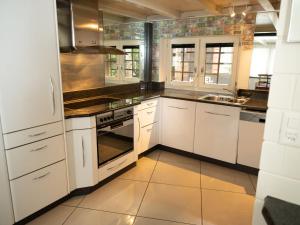 a kitchen with white cabinets and a stove top oven at Apartment Villa Emanuel by Interhome in Zermatt