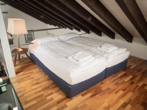 a large bed in a bedroom with a wooden floor at Apartment Villa Emanuel by Interhome in Zermatt